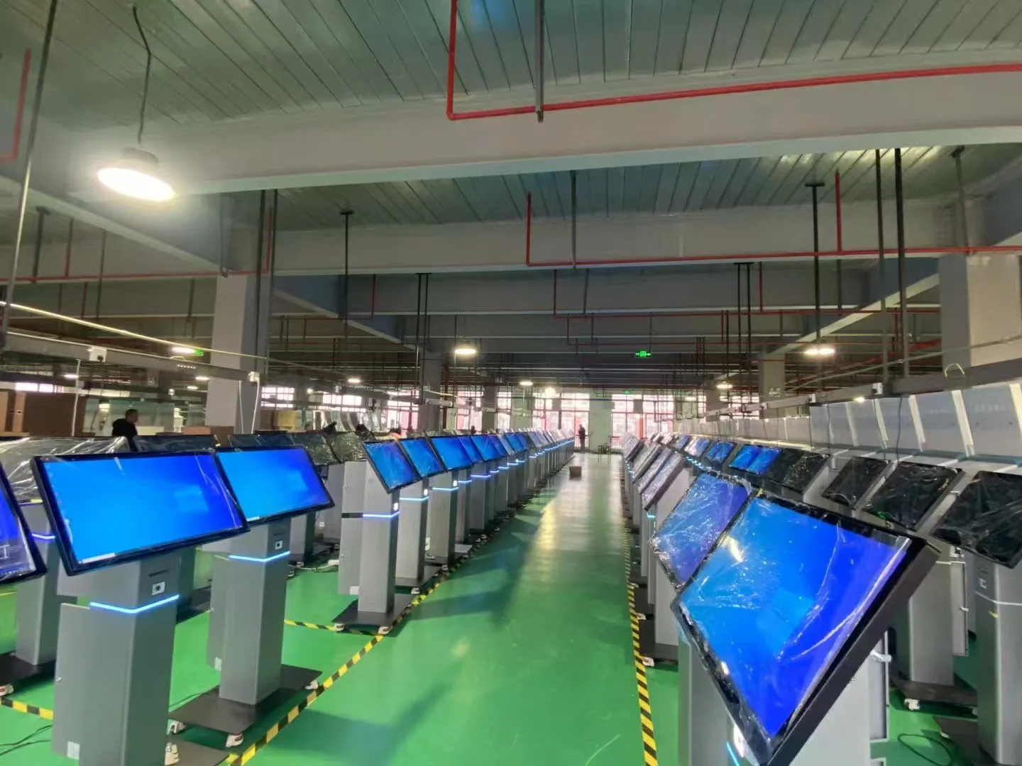 Rows of angled touchscreen information kiosks on the factory testing line